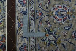 Backside of handmade New Kashan rug showing knot structure and weave density