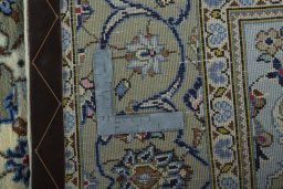 Backside of handmade 2000s Kashan rug showing knot structure and weave density
