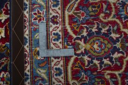 Backside of handmade 2000s Kashan rug showing knot structure and weave density