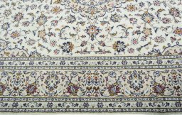 Corner detail of 2000s Kashan rug showing border pattern and Wool pile