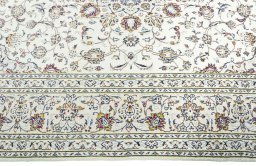 Corner detail of 2000s Kashan rug showing border pattern and Wool pile