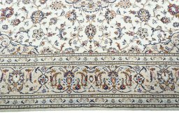 Corner detail of 2000s Kashan rug showing border pattern and Wool pile