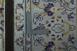 Backside of handmade 2000s Kashan rug showing knot structure and weave density