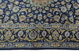 Corner detail of 2000s Kashan rug showing border pattern and Wool pile