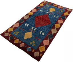 Corner detail of 2000s Persian Gabbeh rug showing border pattern and Wool pile