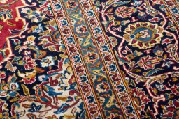 Corner detail of 2000s Kashan rug showing border pattern and Wool pile