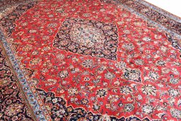 Corner detail of 2000s Kashan rug showing border pattern and Wool pile