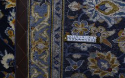 Corner detail of 2000s Kashan rug showing border pattern and Wool pile