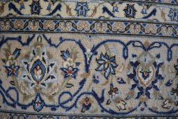 Backside of handmade 2000s Kashan rug showing knot structure and weave density