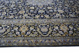 Corner detail of 2000s Kashan rug showing border pattern and Wool pile