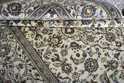 Corner detail of 2000s Kashan rug showing border pattern and Wool pile