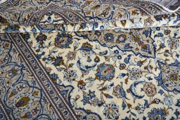 Corner detail of 2000s Kashan rug showing border pattern and Wool pile