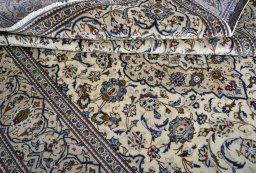 Corner detail of 2000s Kashan rug showing border pattern and Wool pile