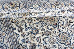 Corner detail of 2000s Kashan rug showing border pattern and Wool pile