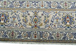 Corner detail of 2000s Kashan rug showing border pattern and Wool pile