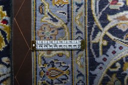 Backside of handmade 2000s Kashan rug showing knot structure and weave density