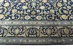 Corner detail of 2000s Kashan rug showing border pattern and Wool pile