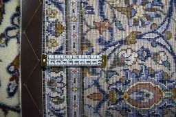 Backside of handmade 2000s Kashan rug showing knot structure and weave density