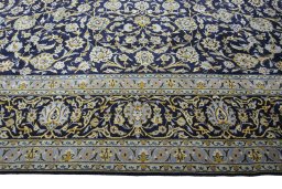 Corner detail of 2000s Kashan rug showing border pattern and Wool pile