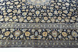 Corner detail of 2000s Kashan rug showing border pattern and Wool pile