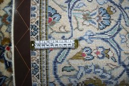 Backside of handmade 2000s Kashan rug showing knot structure and weave density