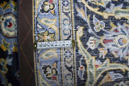 Backside of handmade 2000s Kashan rug showing knot structure and weave density