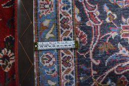 Backside of handmade 2000s Kashan rug showing knot structure and weave density