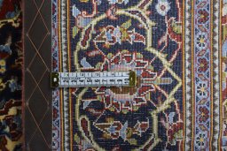 Backside of handmade 2000s Kashan rug showing knot structure and weave density