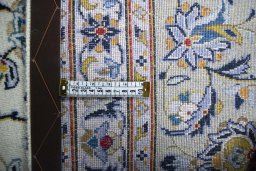 Backside of handmade 2000s Kashan rug showing knot structure and weave density