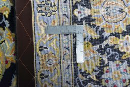 Backside of handmade 2000s Kashan rug showing knot structure and weave density