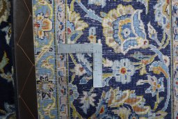 Backside of handmade 2000s Kashan rug showing knot structure and weave density