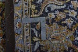 Backside of handmade 2000s Kashan rug showing knot structure and weave density