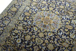 Backside of handmade 2000s Kashan rug showing knot structure and weave density