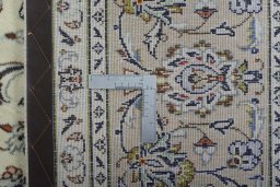 Backside of handmade 2000s Kashan rug showing knot structure and weave density