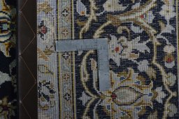Backside of handmade 2000s Kashan rug showing knot structure and weave density