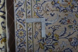Backside of handmade 2000s Kashan rug showing knot structure and weave density