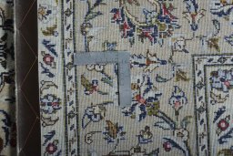 Backside of handmade 2000s Kashan rug showing knot structure and weave density