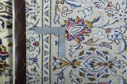 Backside of handmade 2000s Kashan rug showing knot structure and weave density