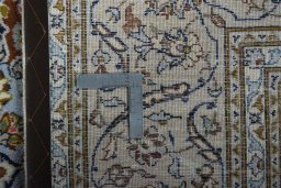 Backside of handmade 2000s Kashan rug showing knot structure and weave density