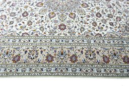 Corner detail of 2000s Kashan rug showing border pattern and Wool pile