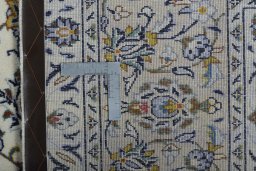 Backside of handmade New Kashan rug showing knot structure and weave density