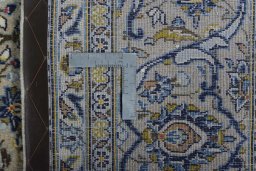 Backside of handmade 2000s Kashan rug showing knot structure and weave density