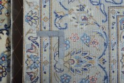 Backside of handmade New Kashan rug showing knot structure and weave density
