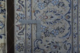 Backside of handmade New Kashan rug showing knot structure and weave density
