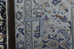 Backside of handmade New Kashan rug showing knot structure and weave density