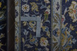 Backside of handmade 2000s Kashan rug showing knot structure and weave density