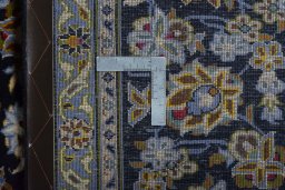 Backside of handmade 2000s Kashan rug showing knot structure and weave density