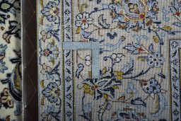 Backside of handmade New Kashan rug showing knot structure and weave density