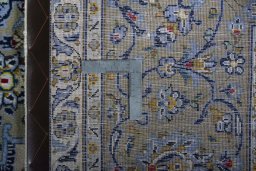 Backside of handmade 2000s Kashan rug showing knot structure and weave density