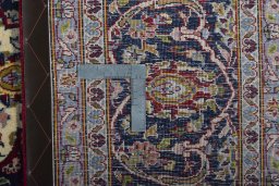Backside of handmade New Kashan rug showing knot structure and weave density